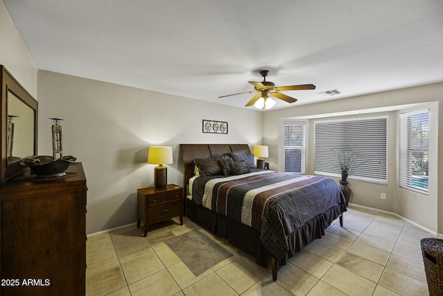 bedroom with baseboards, visible vents, a ceiling fan, and light tile patterned flooring