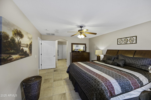 bedroom with visible vents, arched walkways, a ceiling fan, and light tile patterned flooring