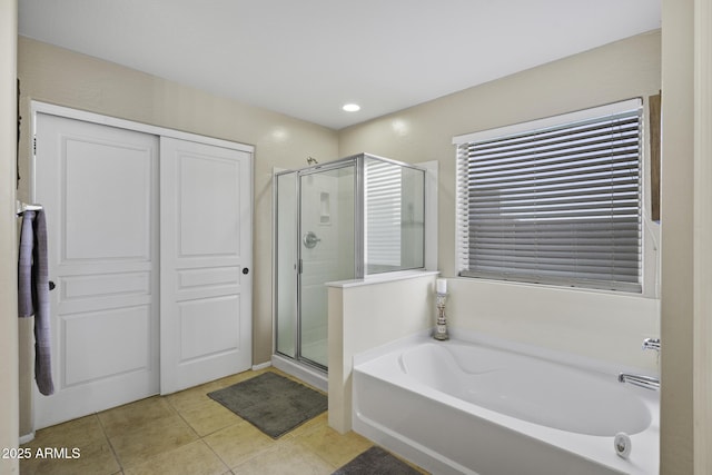 bathroom with a shower stall, a garden tub, and tile patterned flooring