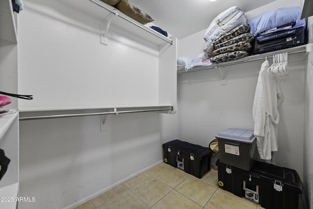 walk in closet with light tile patterned floors