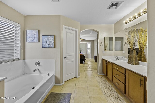 full bath featuring a bath, double vanity, visible vents, tile patterned flooring, and ensuite bathroom