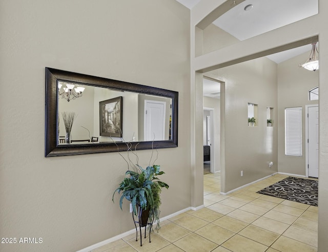 entrance foyer featuring tile patterned flooring, high vaulted ceiling, and baseboards