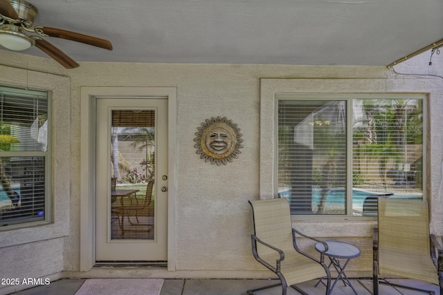 view of exterior entry with a ceiling fan