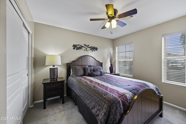 bedroom featuring a closet, light carpet, ceiling fan, baseboards, and visible vents