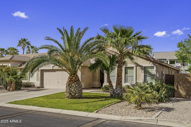 view of front of home with an attached garage, a front lawn, driveway, and stucco siding