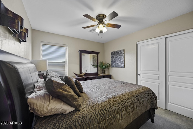 bedroom with visible vents, ceiling fan, carpet flooring, and a closet