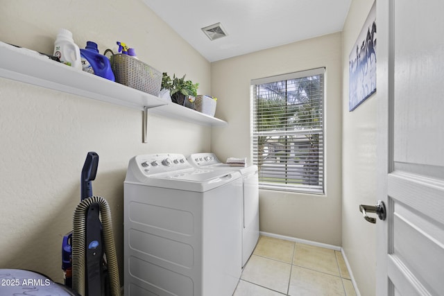 laundry area with laundry area, independent washer and dryer, light tile patterned floors, baseboards, and visible vents