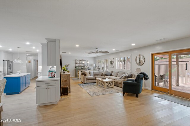 living room with ceiling fan, plenty of natural light, and light wood-type flooring