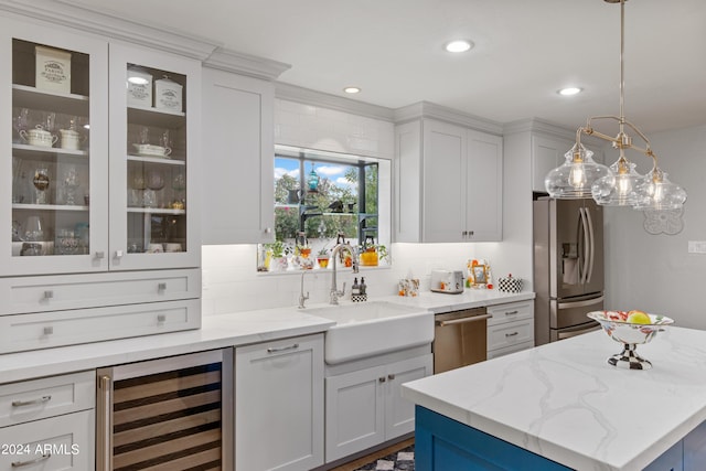 kitchen with pendant lighting, sink, white cabinetry, stainless steel appliances, and wine cooler