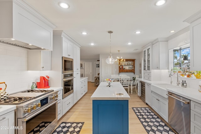 kitchen featuring appliances with stainless steel finishes, white cabinetry, a kitchen island, custom exhaust hood, and light wood-type flooring