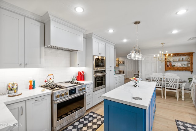 kitchen with a kitchen island, decorative light fixtures, white cabinets, backsplash, and stainless steel appliances