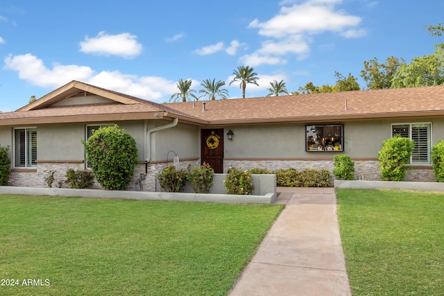 ranch-style home with a front lawn