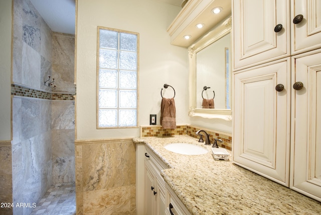 bathroom featuring vanity, tile walls, and tiled shower