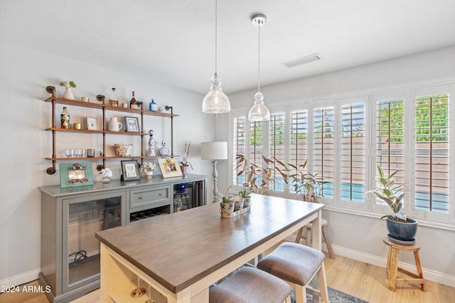 dining room with bar and light wood-type flooring