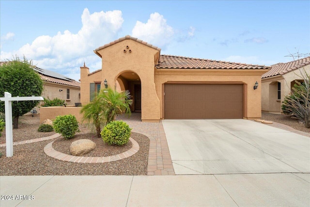 mediterranean / spanish-style house with a garage