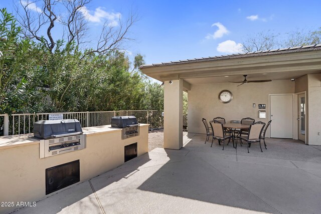 view of patio featuring a grill, a ceiling fan, outdoor dining area, and exterior kitchen