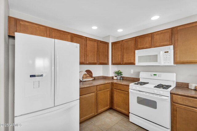 kitchen with white appliances, light tile patterned floors, brown cabinetry, and recessed lighting