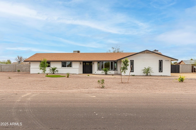 ranch-style house with fence and brick siding