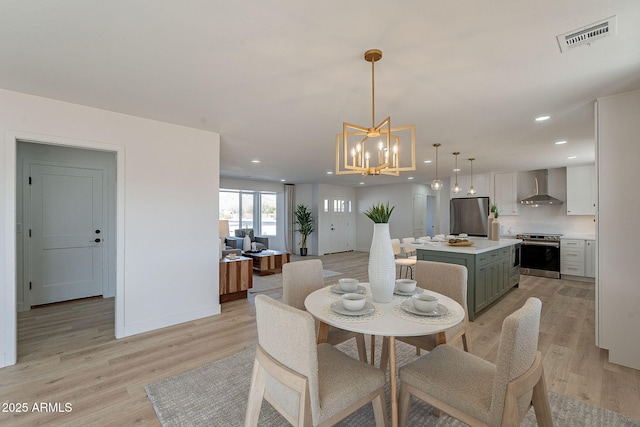 dining area featuring baseboards, light wood-type flooring, visible vents, and recessed lighting