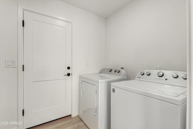 washroom featuring laundry area, light wood finished floors, and washing machine and clothes dryer