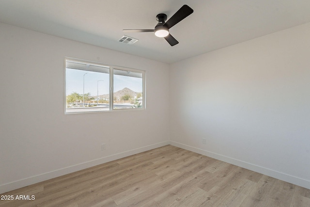 unfurnished room with light wood-style floors, visible vents, baseboards, and a ceiling fan