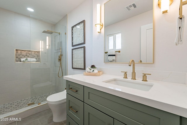 full bath with visible vents, toilet, vanity, a walk in shower, and tile patterned floors