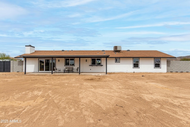 back of house featuring a chimney, a patio area, fence, and central AC