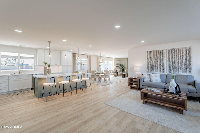 living room featuring light wood finished floors, a wealth of natural light, and recessed lighting