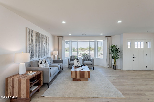 living area with light wood finished floors, baseboards, visible vents, and recessed lighting