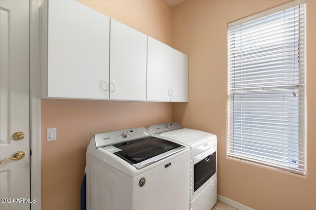 washroom with washer and clothes dryer and cabinets