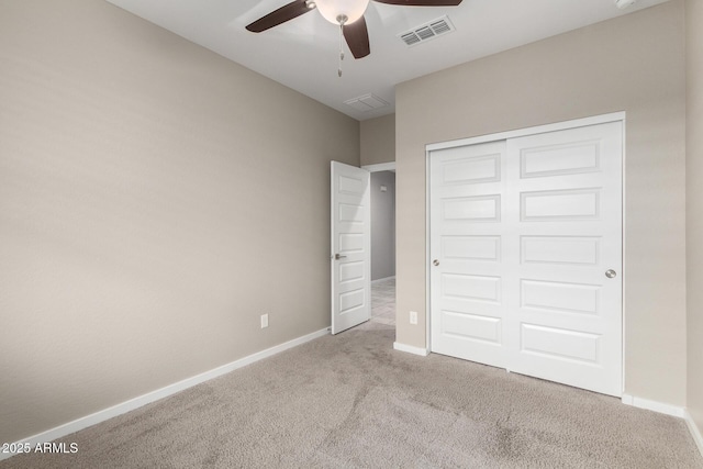 unfurnished bedroom featuring ceiling fan, light colored carpet, and a closet