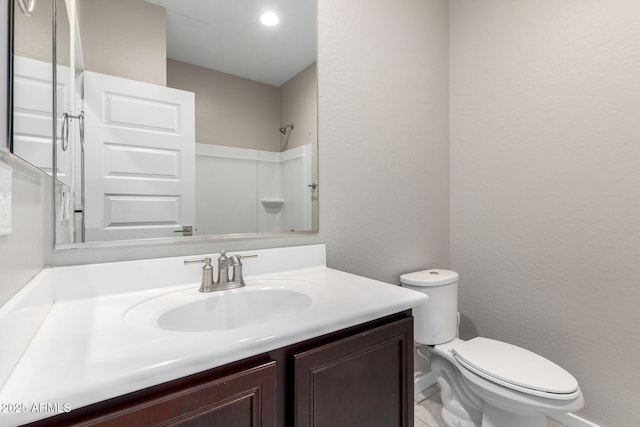 bathroom featuring vanity, toilet, and walk in shower