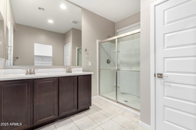 bathroom with tile patterned flooring, vanity, and a shower with shower door