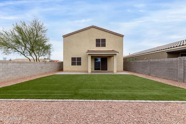 back of property with a yard and a patio