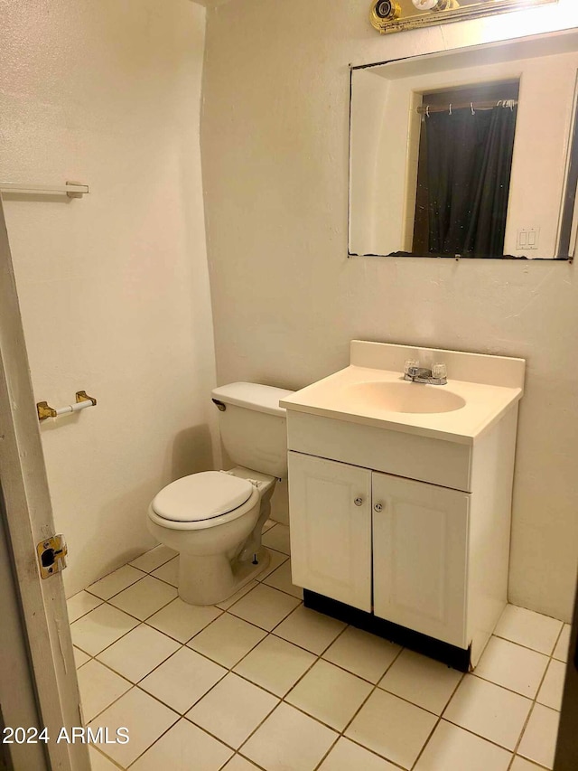 bathroom featuring tile patterned floors, vanity, and toilet