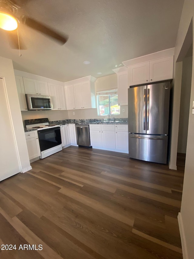 kitchen with white cabinets, dark hardwood / wood-style flooring, and appliances with stainless steel finishes