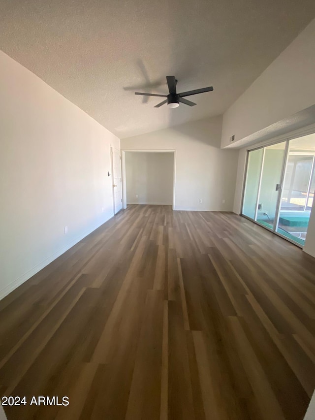 unfurnished living room with a textured ceiling, lofted ceiling, ceiling fan, and dark hardwood / wood-style floors