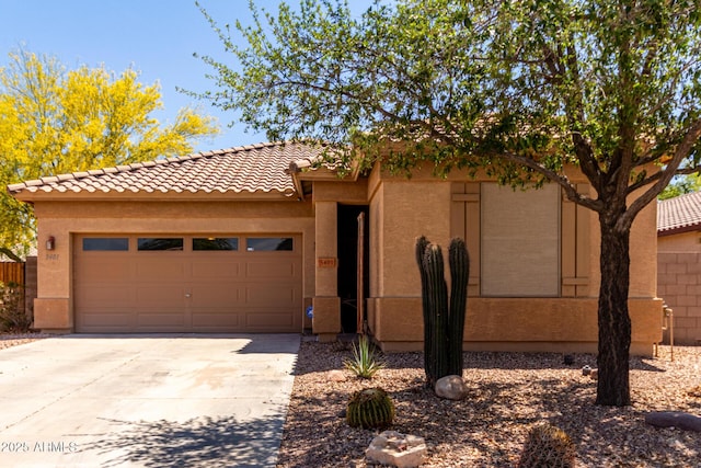 5401 S Dove Holw, Buckeye, AZ 85326 - view of front of house featuring driveway, an attached garage, a tiled roof, and stucco siding