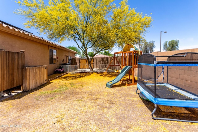 5401 S Dove Holw, Buckeye, AZ 85326 - fenced backyard with a trampoline and a playground