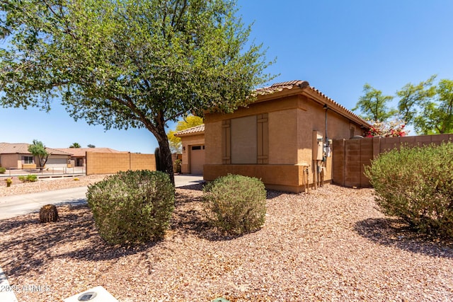 5401 S Dove Holw, Buckeye, AZ 85326 - view of side of property featuring a tiled roof, stucco siding, and fence