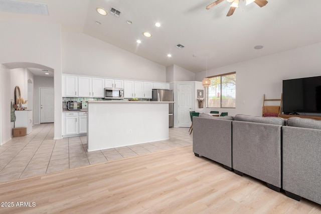 5401 S Dove Holw, Buckeye, AZ 85326 - living room featuring ceiling fan, arched walkways, high vaulted ceiling, light wood finished floors, and recessed lighting
