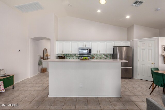 5401 S Dove Holw, Buckeye, AZ 85326 - kitchen featuring appliances with stainless steel finishes, high vaulted ceiling, white cabinetry, light tile patterned floors, and tasteful backsplash