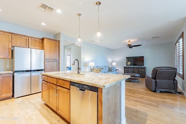 kitchen with ceiling fan, sink, a center island with sink, dishwasher, and refrigerator