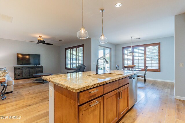 kitchen with light hardwood / wood-style floors, a center island with sink, sink, and a wealth of natural light