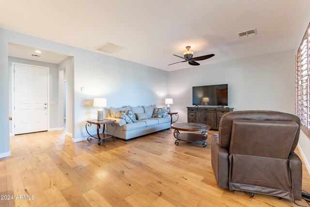 living room featuring light hardwood / wood-style floors and ceiling fan