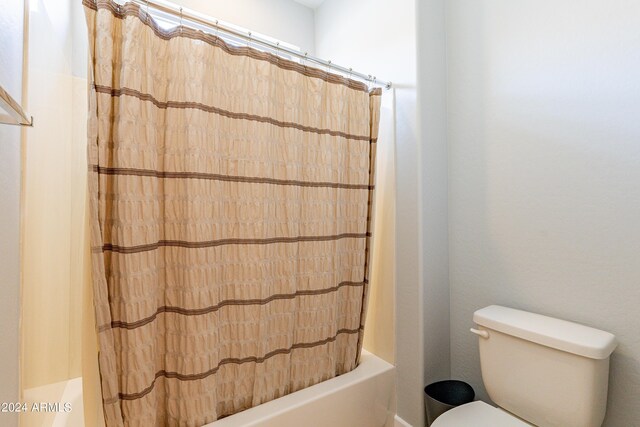 bathroom featuring toilet and shower / bath combo