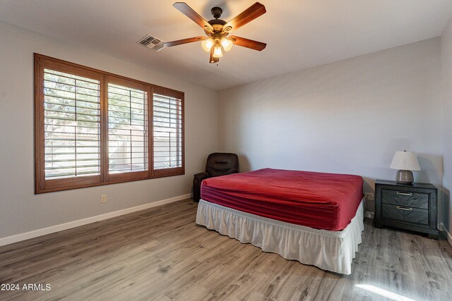 bedroom with ceiling fan and hardwood / wood-style flooring