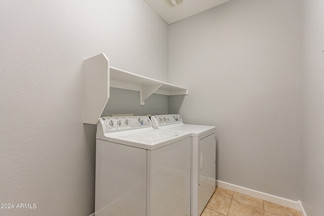 washroom with light tile patterned floors and washer and clothes dryer