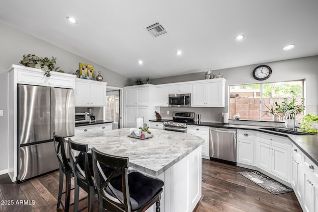 15027 N 61st Pl, Scottsdale, AZ 85254 - kitchen with visible vents, a sink, decorative backsplash, dark wood-type flooring, and appliances with stainless steel finishes