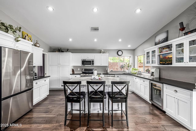 15027 N 61st Pl, Scottsdale, AZ 85254 - kitchen with visible vents, backsplash, beverage cooler, appliances with stainless steel finishes, and a kitchen breakfast bar
